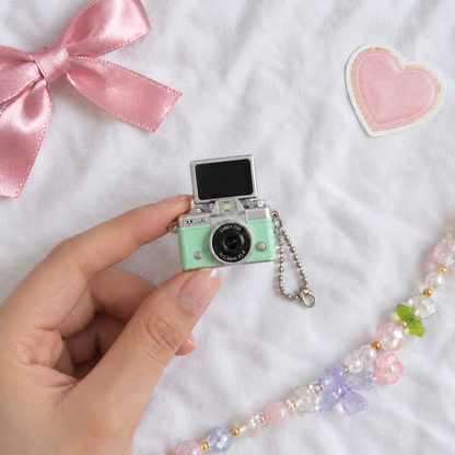 Mini Flip Screen Keychain Camera in Mint Green, held between thumb and finger for size